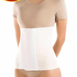 Kobieta w beżowej bluzce i białym pasie uciskowym na brzuch, z rękami za plecami, na jasnym tle.