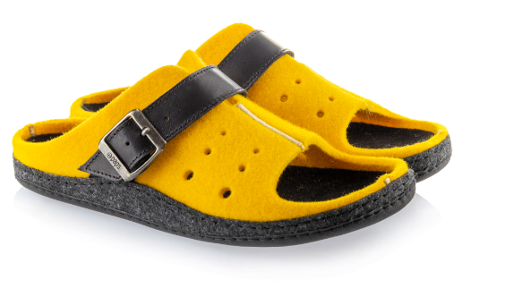Żółte kapcie z czarnym paskiem i otwartym palcem, na miękkiej czarnej podeszwie.
