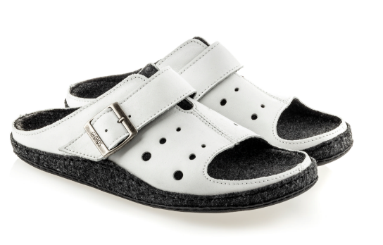 Białe kapcie z czarnymi wstawkami i regulowanym paskiem na rzep, przeznaczone do użytku domowego.