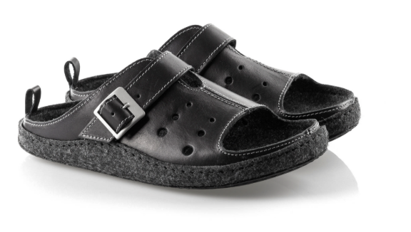 Czarne kapcie z szerokim paskiem i metalową klamrą, wykonane z miękkiego materiału, na podeszwie z filcu.