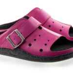 Różowe kapcie z czarną podeszwą, z regulowanym paskiem na sprzączkę i otworami wentylacyjnymi.