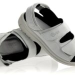 Białe sandały na rzepy z czarnym wyściółką i otwartymi palcami, ustawione na białym tle.