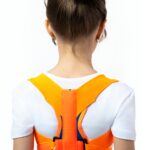 Młoda dziewczyna z brązową fryzurą w kok, nosi żółto-pomarańczowy pas bezpieczeństwa na białej koszulce.