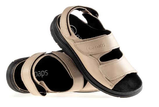 Beżowe sandały na czarnej podeszwie z dwoma szerokimi rzepami, ułożone na boki.