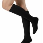 Para czarnych podkolanówek na nogach mężczyzny, z widoczną częścią ud i łydki, na białym tle.