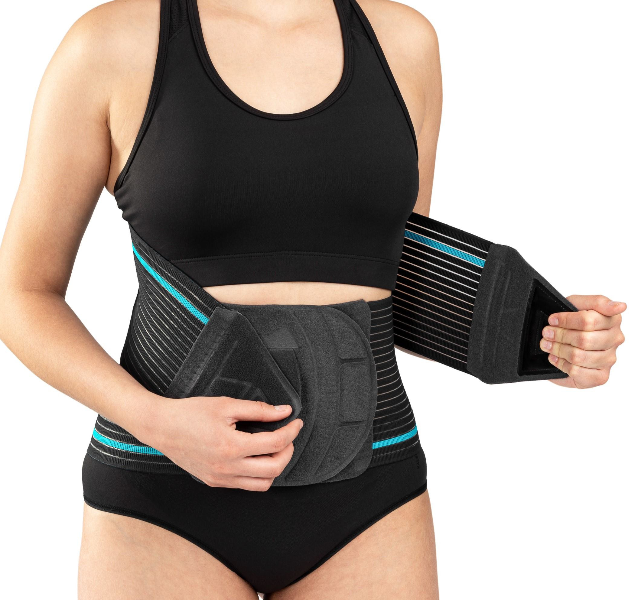 Kobieta nosi pas do ćwiczeń z poduszkami na brzuchu i ramionach, wykonując ćwiczenie w bieliźnie sportowej.