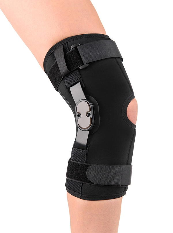 Orteza kolana z regulowanymi paskami i metalowym elementem wspierającym, na prawym kolanie osoby.