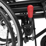 Uchwyt i pedał wózka inwalidzkiego z czerwonym przyciskiem i logo Tetra.