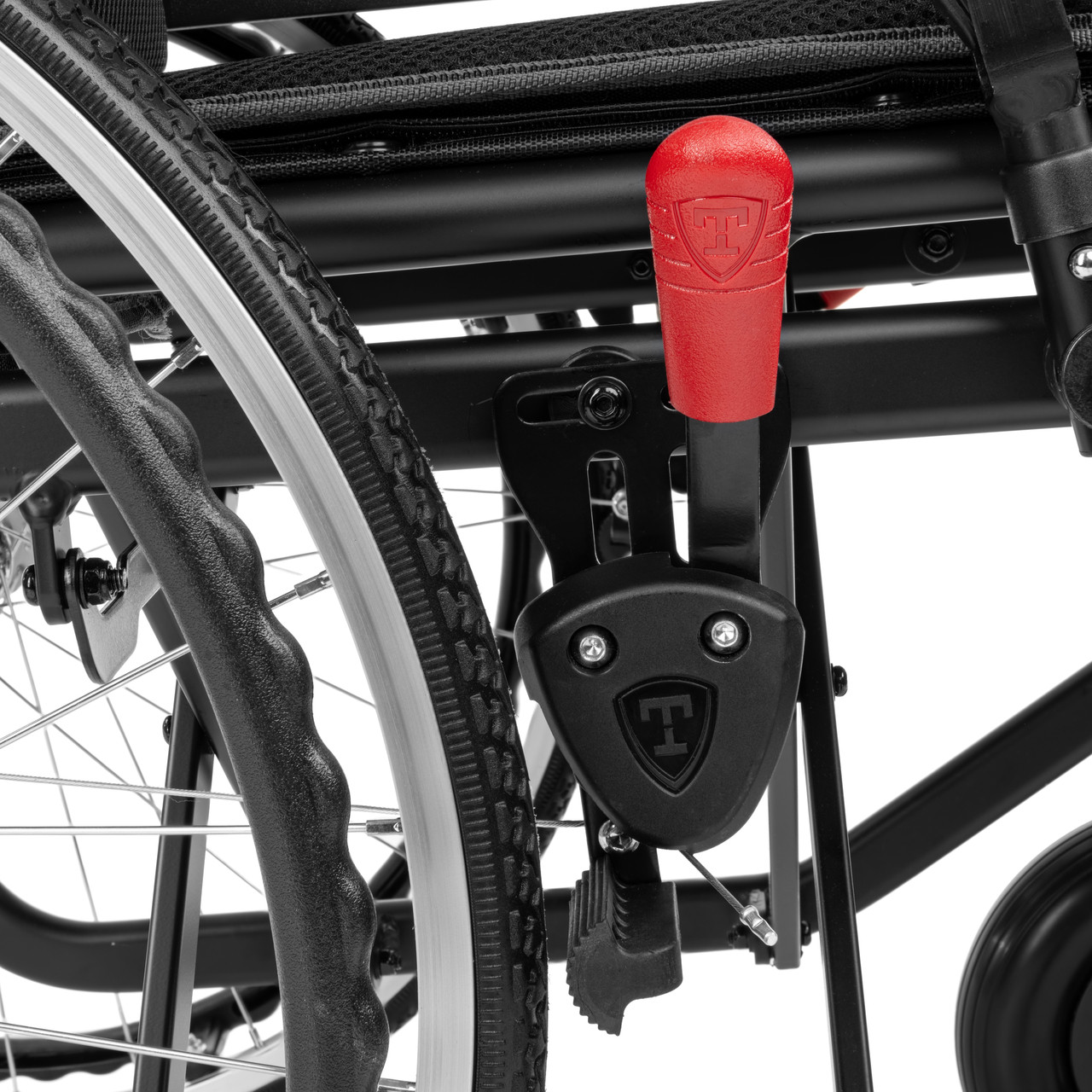 Uchwyt i pedał wózka inwalidzkiego z czerwonym przyciskiem i logo Tetra.