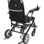 Lekki, składany wózek inwalidzki z czarnym siedziskiem, oparciem i podnóżkami, z czterema kołami i regulowanym podłokie