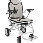 Lekki, składany wózek inwalidzki z regulowanymi podłokietnikami i pasami bezpieczeństwa, na czterech kołach.