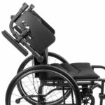 Wózek inwalidzki z regulowanym podnóżkiem i oparciem, czarny, na dużych kołach z metalową ramą.
