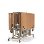 Stół do łóżka z drewnianymi panelami i metalową ramą na kółkach, przeznaczony do użytku w placówkach medycznych.