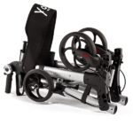 Składany wózek inwalidzki z czarnym siedziskiem, czterema kołami i metalową ramą, przeznaczony do transportu osoby niepe