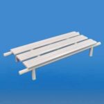 Biała ławka na czterech nogach na niebieskim tle.