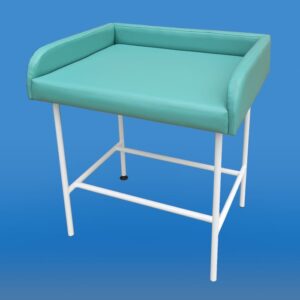 Stół do przewijania niemowląt z miękką, zieloną nakładką i białą metalową ramą na czterech nogach.