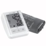 Ciśnieniomierz z wyświetlaczem pokazującym 124/75 mm Hg i puls 82, obok mankiet do pomiaru ciśnienia.