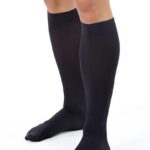 Para czarnych, długich pońcuchów sięgających do kolan, na nogach osoby.