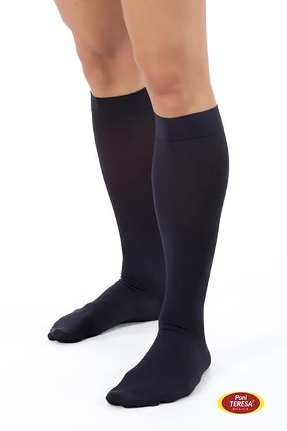 Para czarnych, długich pońcuchów sięgających do kolan, na nogach osoby.