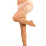 Nogi kobiety w pońcuchach samonośnych, z widocznym gładkim brzuchem i bez górnej części odzieży, na białym tle.