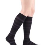 Długie skarpety w czerni i fioletowe paski na nogach osoby stojącej.