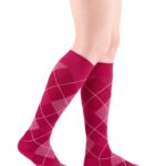 Czerwone podkolanówki z białym i różowym wzorem rombów i linii argyle na nogach.