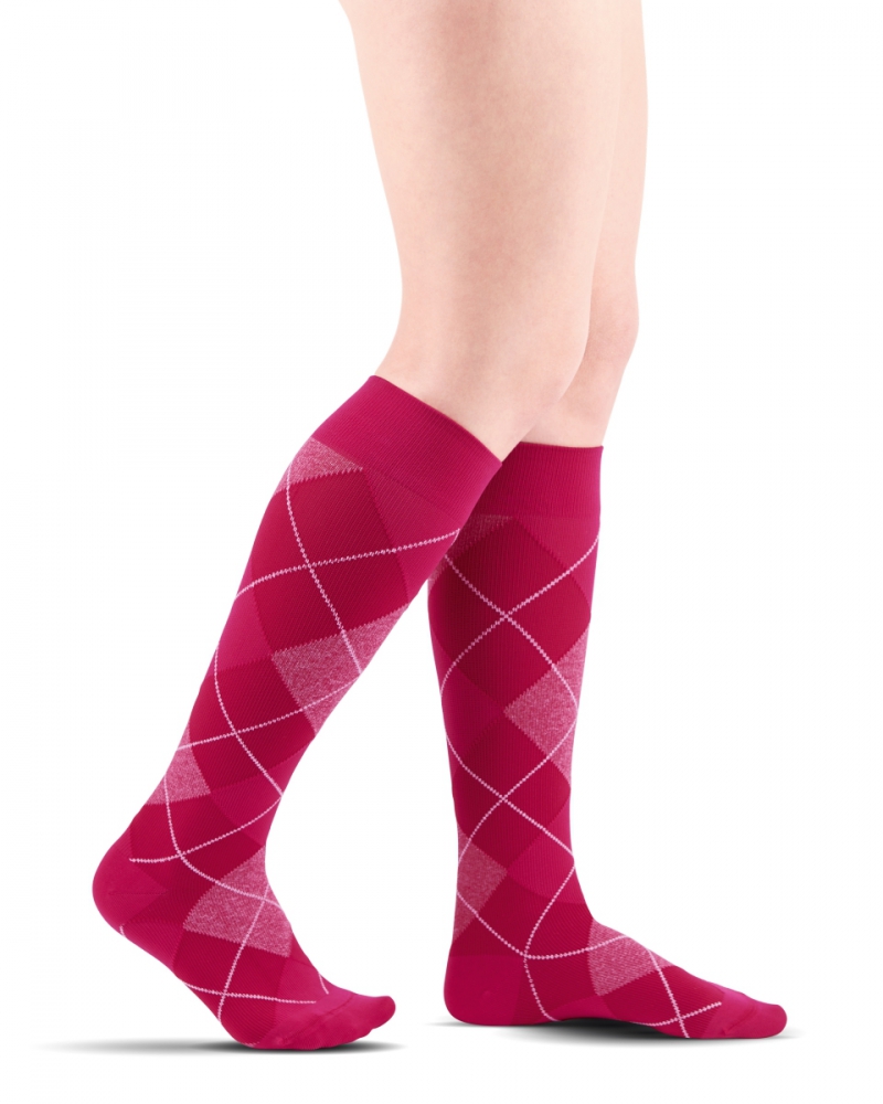 Czerwone podkolanówki z białym i różowym wzorem rombów i linii argyle na nogach.