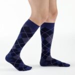 Para ciemnoniebieskich skarpet z wzorem w romby na nogach mężczyzny.