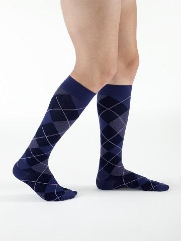 Para ciemnoniebieskich skarpet z wzorem w romby na nogach mężczyzny.