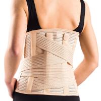 Kobieta z czarnym topem nosi ortezę na plecach, zapewniającą wsparcie i stabilizację kręgosłupa.