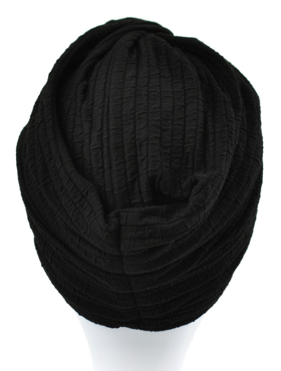 Czarna, miękka czapka z szerokim, elastycznym brzegiem, ułożona na białej powierzchni.
