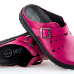 Para różowych, zamkniętych pantofli z czarną podeszwą i metalową klamrą na szerokim pasku.