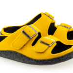 Żółte kapcie z czarnymi wstawkami, dwoma paskami z metalowymi klamrami i miękką podeszwą.