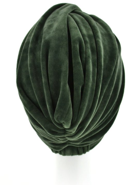 Zielony, miękki turban z plisami, wykonany z welurowego materiału.