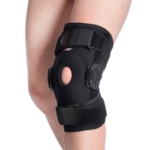 Orteza kolana z otworem na rzep, czarna, mocowana taśmami na udzie i podudzie.