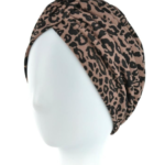 Turban w brązowo-czarne leopardie na białej głowie.