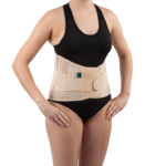 Osoba nosząca pas ortopedyczny na talii, ubrana w czarny top i majtki, stojąca na białym tle.