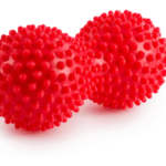 Dwa czerwone, kuliste przedmioty pokryte licznymi wypustkami, przypominające piłki z kolcami.