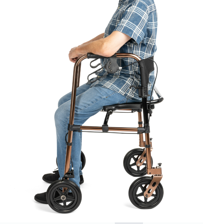 Osoba siedząca na lekkim, składanym wózku inwalidzkim z metalową ramą i czterema kołami, ubrana w koszulę w kratę i j