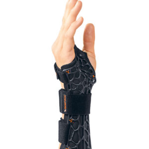 Dłoń w opasce ortopedycznej z czarnej siateczki, uniesiona w górę, z palcami lekko rozłożonymi.