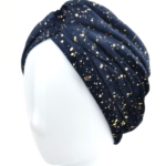 Niebieska opaska na głowę z złotymi plamkami, ułożona na białej głowie.