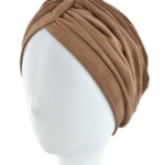 Brązowa, miękka chusta turbanowa na głowie na białej głowie manekina.