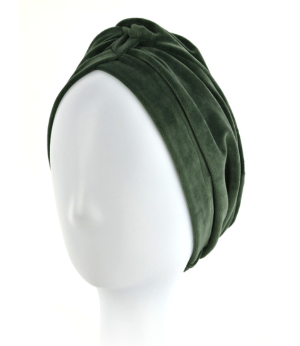 Zielona, miękka turbanowa opaska na głowę na manekinie bez twarzy.