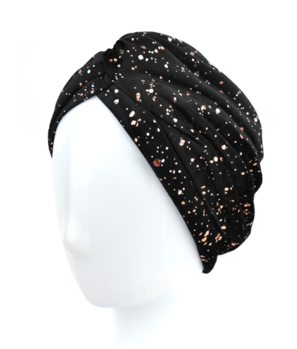 Czarna opaska na głowę z różnokolorowymi plamkami, ułożona na białej głowie manekina.