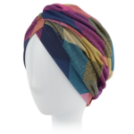 Kolorowa, wielowarstwowa chusta z wzorzystej tkaniny na białej głowie manekina.