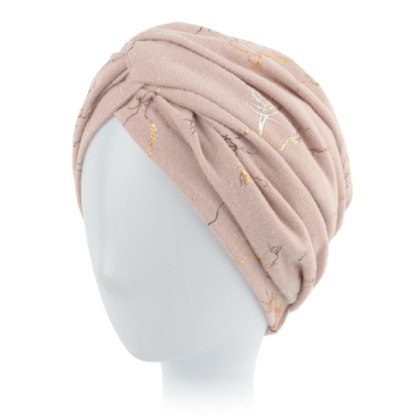 Różowa czapka z plisami i złotymi oraz srebrnymi akcentami, ułożona na białej głowie.