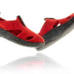 Czerwone, miękkie sandały z czarną podeszwą i zapięciem na rzepy, przeznaczone do chodzenia po domu lub na plażę.