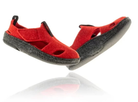 Czerwone, miękkie sandały z czarną podeszwą i zapięciem na rzepy, przeznaczone do chodzenia po domu lub na plażę.