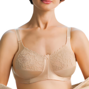 Kobieta w beżowym biustonoszu z koronkowymi zdobieniami i cienkimi ramiączkami, uśmiechnięta, z widocznym dekoltem.