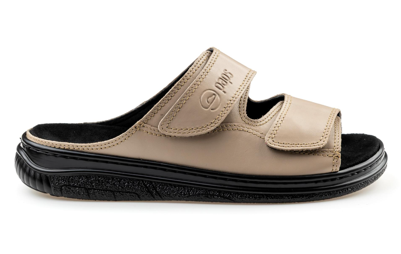 Kapcie na miękkiej podeszwie z dwoma regulowanymi rzepami, w kolorze beżowym, z czarnym wkładem i podeszwą.